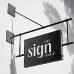2 Shots of Hanging Sign Mockup on Blank Wall