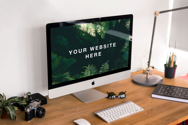 3/4 View of an iMac on a Wooden Desk