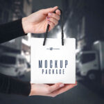 3 Front-View Mockups of a Square Paper Bag in Hand