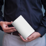 A Book Cover Mockup Held by a Man