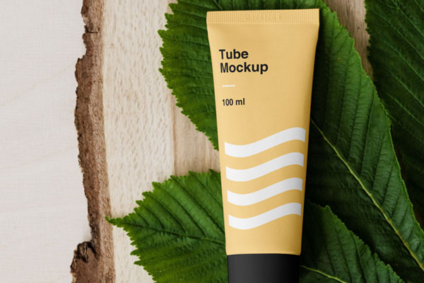 A Cosmetic Tube on Bunch of Leaves and a Piece of Wood Mockup