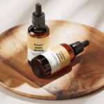 Amber Essential Bottle Mockup in 4 Showcases