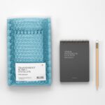 Branding Mockup Featuring Bubble Mailer Envelope and Notebook in Top View