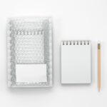Branding Mockup Featuring Bubble Mailer Envelope and Notebook in Top View