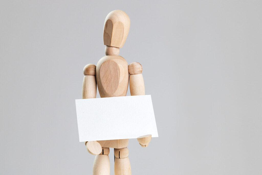 Business Card Held in Hands of a Wooden Manikin Mockup