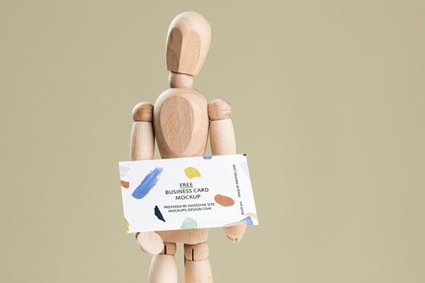Business Card Held in Hands of a Wooden Manikin Mockup