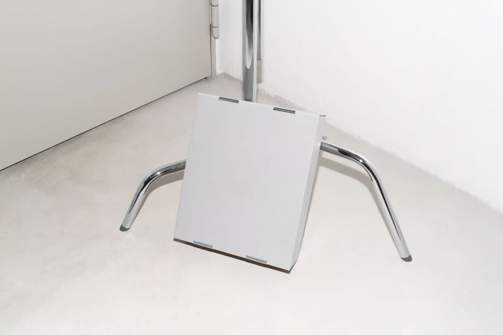 Cardboard Box Leaning Against Tripod Mockup