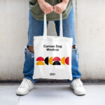 Casual Outdoor Man Holding Canvas Bag Mockup from Front View