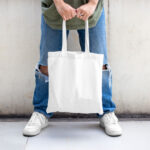 Casual Outdoor Man Holding Canvas Bag Mockup from Front View