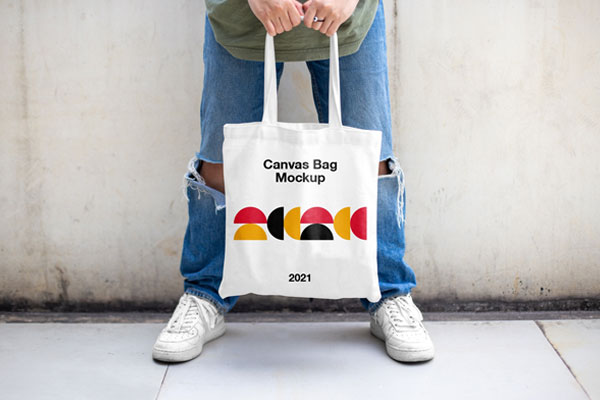 Casual Outdoor Man Holding Canvas Bag Mockup from Front View