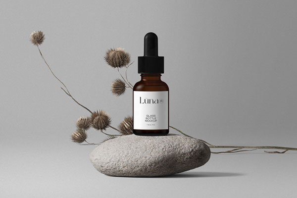 Cosmetic Bottle Mockup with Flower on Stone in Front View