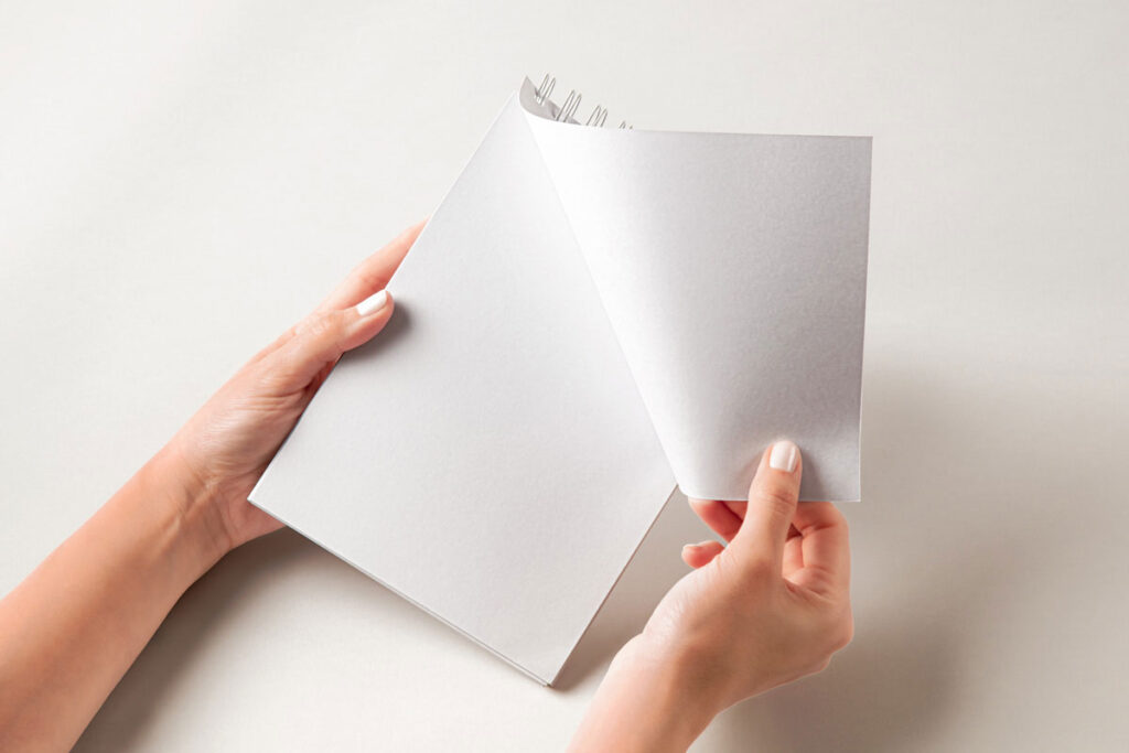 Facing View of Hand Holding Ringed Notebook Mockup