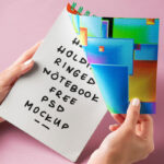 Facing View of Hand Holding Ringed Notebook Mockup