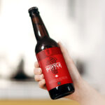 Female Hand Holding Glass Beer Bottle in the Air Mockup