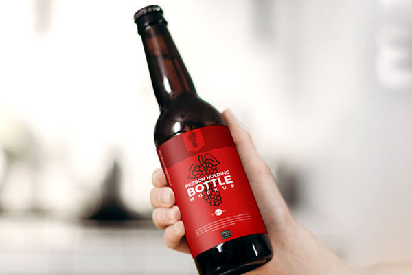 Female Hand Holding Glass Beer Bottle in the Air Mockup