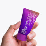 Front View Hand Holding Cosmetic Tube Mockup