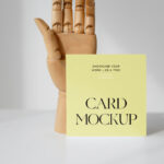 Front View of a Standing Card Mockup with a Wooden Hand