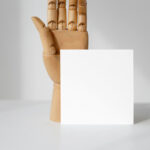 Front View of a Standing Card Mockup with a Wooden Hand