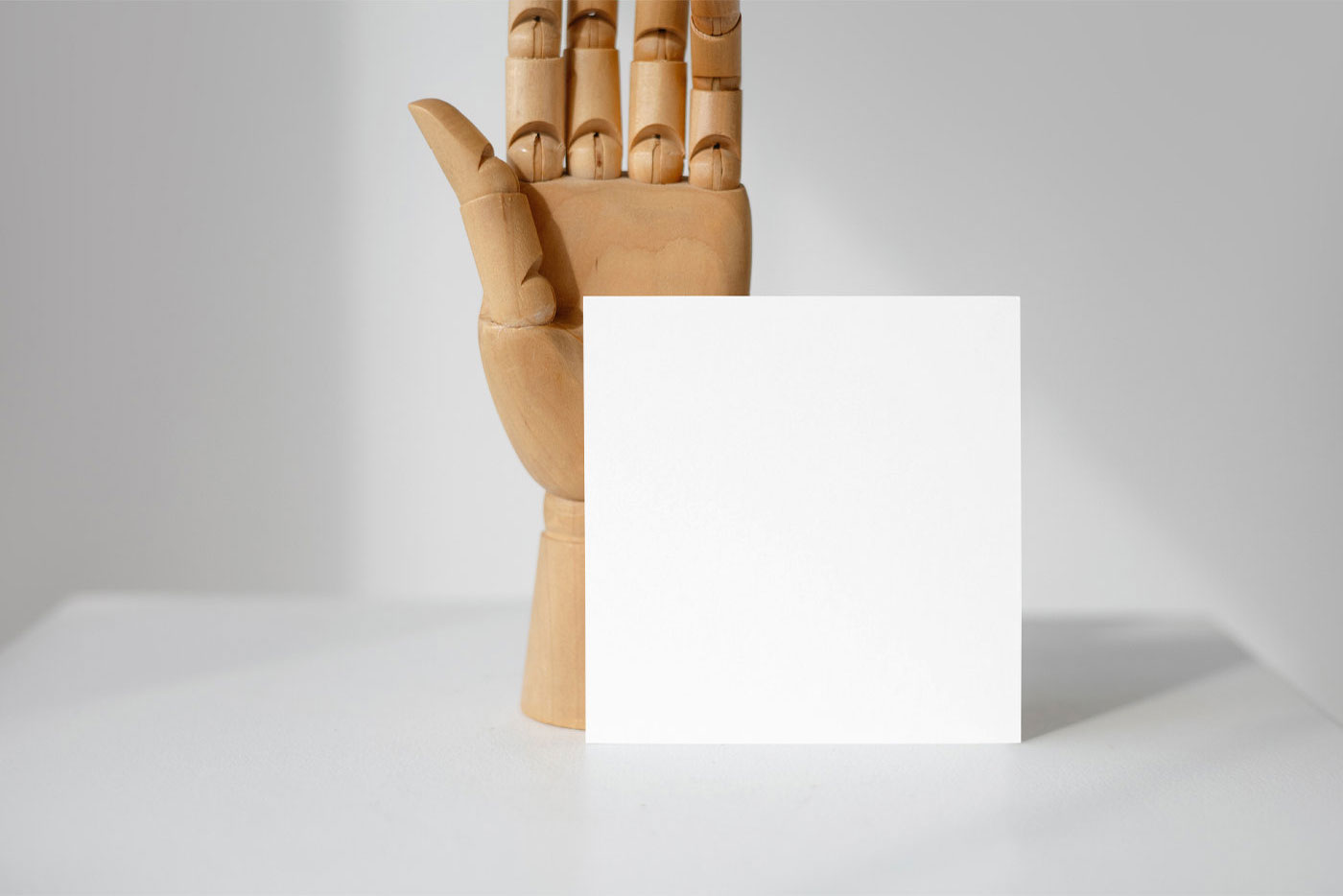 Front View of a Standing Card Mockup with a Wooden Hand FREE PSD