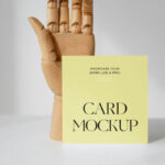 Front View of a Standing Card Mockup with a Wooden Hand