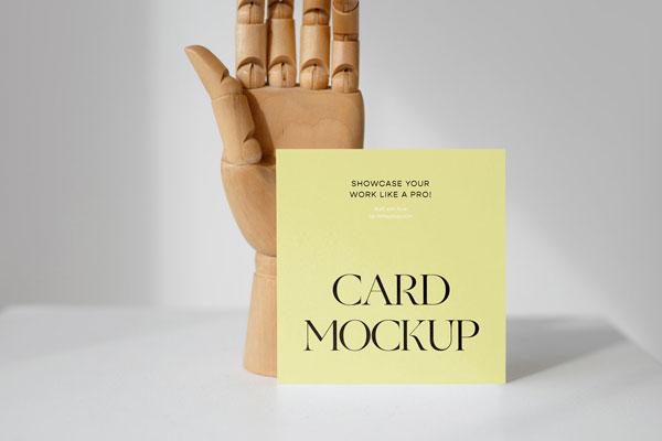 Front View of a Standing Card Mockup with a Wooden Hand