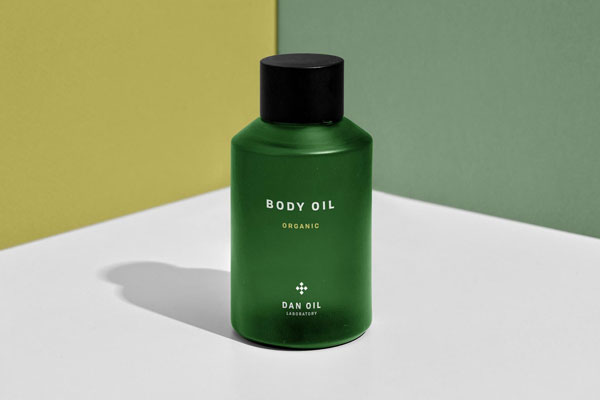 Front View of Body Oil Bottle at the Corner of Two Walls Mockup
