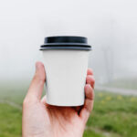 Front View of Hand Holding Coffee Cup Mockup in Park