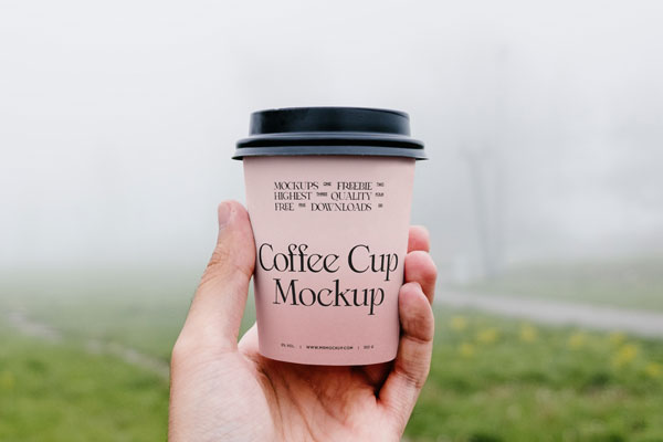 Front View of Hand Holding Coffee Cup Mockup in Park