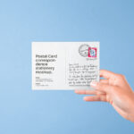Front View of Hand Holding Postal Card Mockup