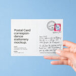 Front View of Hand Holding Postal Card Mockup