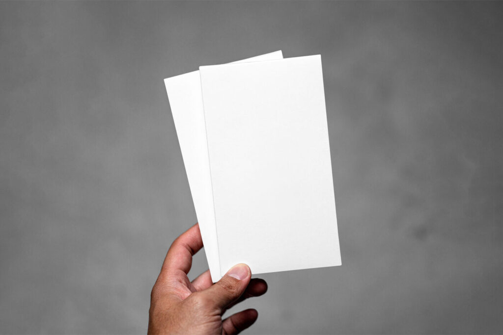Front View of Hand Holding Vertical Leaflets Mockup