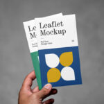 Front View of Hand Holding Vertical Leaflets Mockup