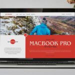 Front View of MacBook Pro on Table Surrounded by Vases Mockup