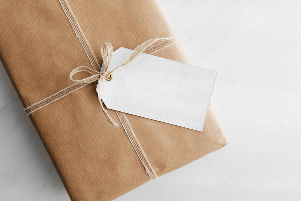 Gift Card Mockup Hung From Wrapped Package in Top View