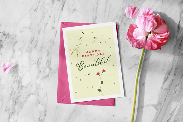 Greeting Card and Envelope Mockup Next to a Flower