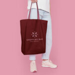 Half-Side View Cotton Tote Bag Featuring Someone Holding It Mockup