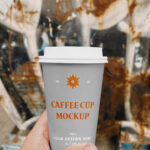 Hand Holding a Coffee Cup on a Street Mockup