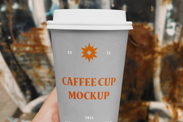Hand Holding a Coffee Cup on a Street Mockup