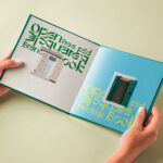 Hand Holding Hardcover Open Book Mockup in Perspective View