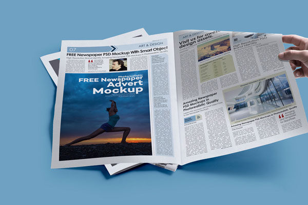 Hand Holding Opened Newspaper Laid on the Ground Mockup