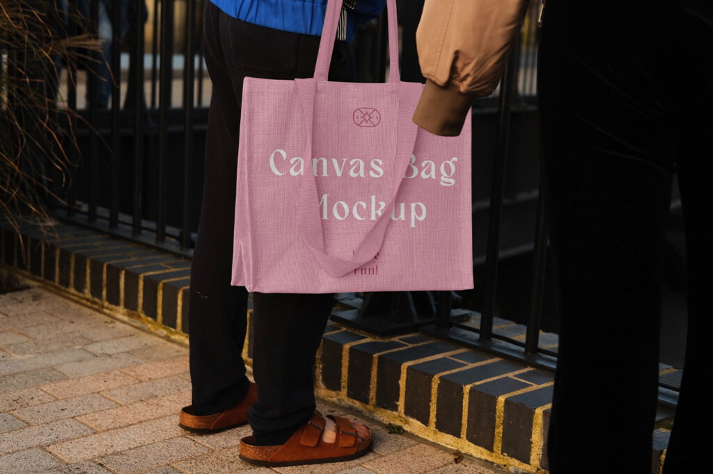 Hand Holding the Realistic Medium Canvas Bag Mockup