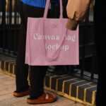 Hand Holding the Realistic Medium Canvas Bag Mockup