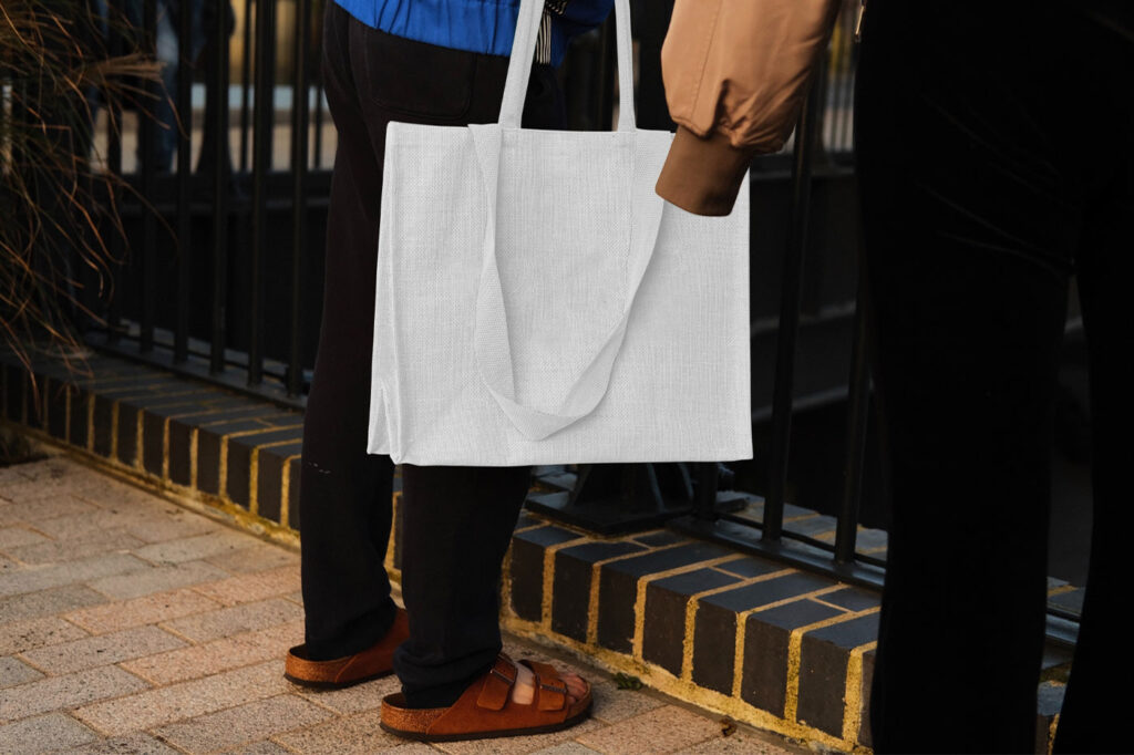 Hand Holding the Realistic Medium Canvas Bag Mockup