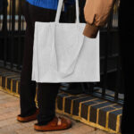 Hand Holding the Realistic Medium Canvas Bag Mockup