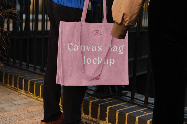 Hand Holding the Realistic Medium Canvas Bag Mockup