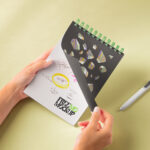Hands Holding Spiral Notebook Mockup in Perspective Sight
