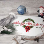 Horizontal Postcard Laid in Perspective Along with Christmas Ornaments Mockup