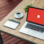 Laptop Mockup on Wooden Desk Outdoor at a 34 Angle View