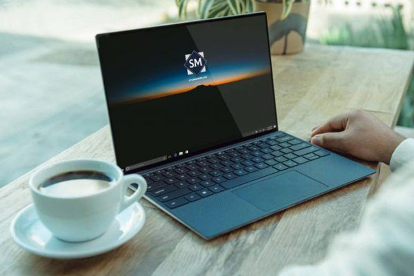 Laptop on a Table in Front of a Man Mockup