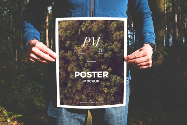 Man Holding a Nature-Oriented Poster Mockup